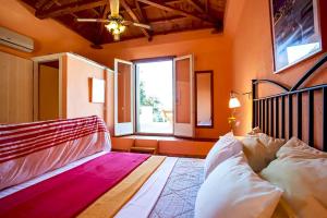 a bedroom with a large bed and a window at Villa Kalypso and Villa Kirki in Skopelos Town