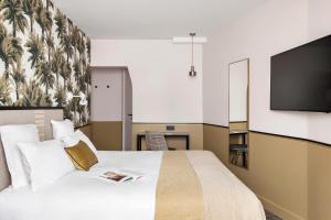 a hotel room with a bed and a flat screen tv at Doisy Etoile in Paris