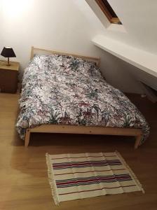 1 dormitorio con 1 cama con colcha de flores en Charmant duplex à 200m de la cathédrale, en Lieja