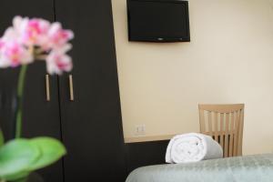 a room with a bed and a tv and flowers at Hotel Villa Delle Rose in Rome