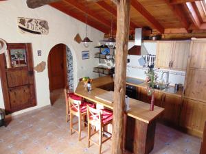 a kitchen with a wooden table and chairs at Renllon in Lomo de Arico