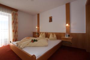 una camera da letto con un grande letto bianco con fiori sopra di Lechlihof a Ischgl