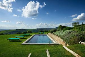a swimming pool in a field with three picnic tables at B&B Palazzolo La Foce in Chianciano Terme