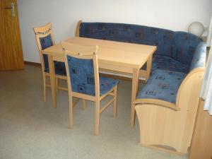 a wooden table with two chairs and a couch at Haus Mondspitze in Bürserberg