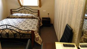 a small room with a bed and a desk with a computer at Buožinta in Buožėnai