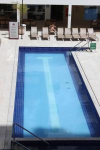 una gran piscina azul con sillas en un edificio en Casa da Madeira Home Service, en Caldas Novas