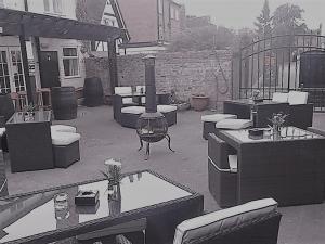 a patio with a fireplace and couches and a fire pit at The Queens Head in Stratford-upon-Avon
