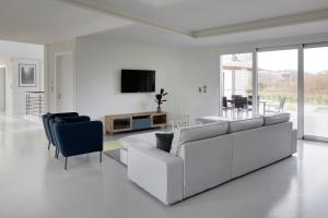 a white living room with a white couch and chairs at Villa Enea by FeelFree Rentals in San Sebastián