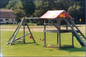 un parque infantil con columpios en un campo en Port Lodge Motel en Pulaski