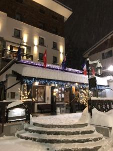 um edifício com luzes de Natal e escadas na neve em Hotel Edelweiss 3 Stelle SUPERIOR em Breuil-Cervinia