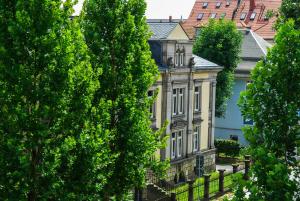 um edifício antigo com árvores em frente em Casa Hostel Pirna em Pirna
