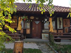 a log cabin with a wooden door and a porch at Etno Kompleks Kapetan Mišin breg in Donji Milanovac