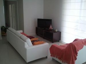 sala de estar con sofá blanco y TV en Mallorca Penthouse - cobertura com piscina privativa e vista pro mar, en Bombinhas
