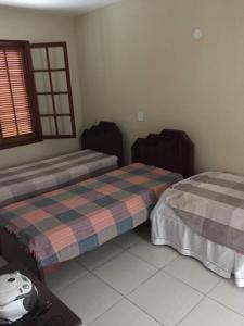 um quarto com 2 camas e uma janela em Lindo Apartamento praia e quiosque abertos em Cabo Frio