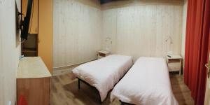 2 camas en una habitación pequeña con sábanas blancas en Il Veliero B&B Roma, en Osteria dellʼ Osa