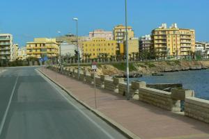 a road in a city next to a river with buildings at Liberty House in Marsala