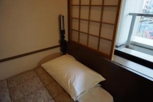 Postel nebo postele na pokoji v ubytování Yokohama Minatomirai Manyo Club