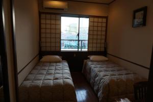 Postel nebo postele na pokoji v ubytování Yokohama Minatomirai Manyo Club