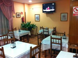 restauracja ze stołami i telewizorem na ścianie w obiekcie Hotel Praderón w mieście San Sebastián de los Reyes