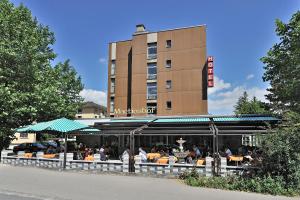 un ristorante con persone sedute ai tavoli di fronte a un edificio di Martinshof a Zuchwil
