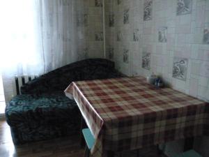 ズラトウーストにあるApartment in Zlatoustのベッド1台、テーブル(プライド毛布付)が備わる客室です。