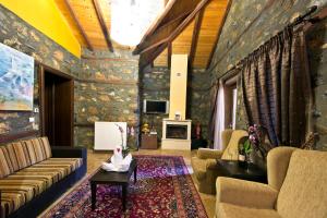 a living room with a couch and a table at Chalet Lithos in Palaios Agios Athanasios