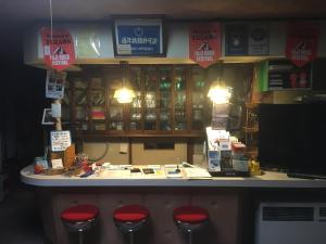 a bar with red stools in front of a store at Lodge Yashiro in Yuzawa