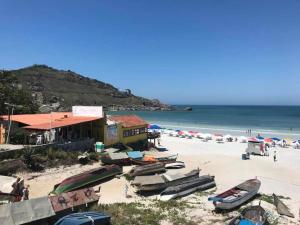 una playa con barcos en la arena y un edificio en Le Bon Vivant 203, en Arraial do Cabo