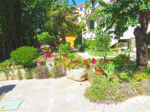un giardino pieno di fiori e piante di Apartments Milica 961 a Medulin