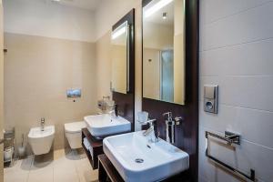 a bathroom with two sinks and a toilet and a mirror at Hotel Villa Bianca in Liptovský Mikuláš +43 photos