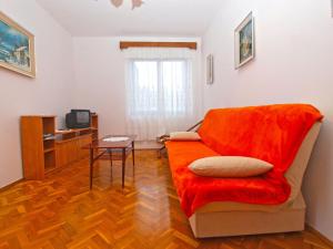 a living room with a red couch and a table at Apartments Dvorine 1210 in Banjole