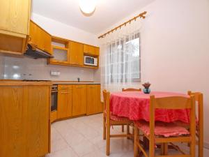 a kitchen with a table with a red table cloth at Apartments Dvorine 1210 in Banjole