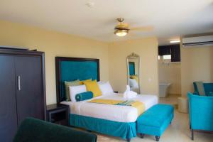 um quarto com uma cama e duas cadeiras azuis em Best Western Plus Accra Beach Hotel em Teshi