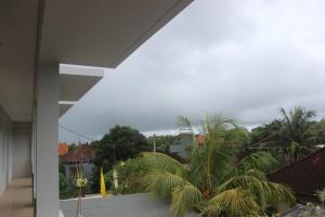 a view from the balcony of a house with palm trees at Adi Bali Homestay in Uluwatu