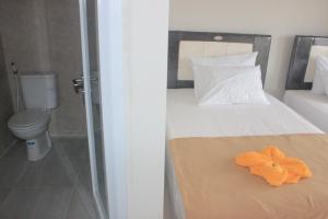 a bedroom with a bed with an orange flower on it at Adi Bali Homestay in Uluwatu +25 photos
