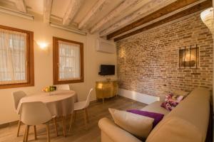 - un salon avec un canapé et un mur en briques dans l'établissement Nike Appartamenti, à Venise