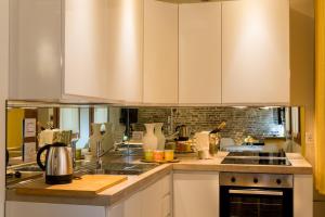 a kitchen with white cabinets and a counter top at Nike Appartamenti in Venice +8 photos