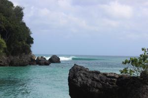 a view of the ocean from a rocky beach at Adi Bali Homestay in Uluwatu