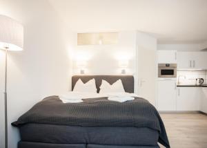 - une chambre avec un grand lit aux murs blancs dans l'établissement Appartement Brink Am Waltenberg 70, à Winterberg