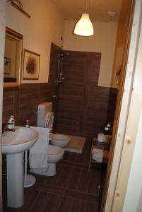 y baño con 2 aseos, lavamanos y ducha. en Agriturismo Petrarosa, en Neviano degli Arduini