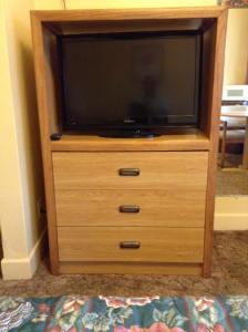 a wooden dresser with a television on top of it at Mark Twain Motor Inn in Elmira