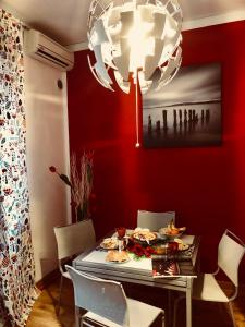 une salle à manger avec une table et un lustre dans l'établissement Corso 126 Guest House Salerno, à Salerne
