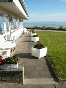 a patio with a table and chairs and flowers at Gaestehaus Cap Hoorn in Helgoland
