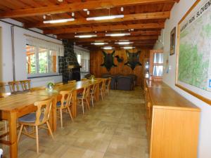uma sala de jantar com mesas e cadeiras de madeira em Poľovnícka chata Štefana em Mlynky 