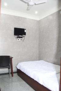 哈尔德瓦尼Hotel Silk的一间带床、书桌和电视的卧室