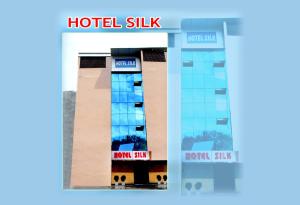 哈尔德瓦尼Hotel Silk的带有酒店标志的酒店式建筑