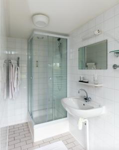 uma casa de banho com uma cabina de duche em vidro e um lavatório. em De Herberg van Anderen em Anderen
