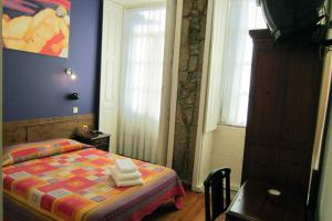 ein Schlafzimmer mit einem Bett mit Handtüchern darauf in der Unterkunft Duas Nações Guest House in Porto