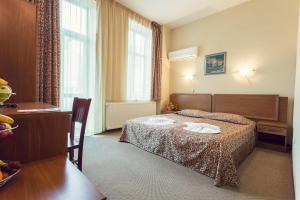 a hotel room with a bed and a table at Hotel Varosha in Lovech