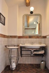 een badkamer met een wastafel en een spiegel bij La Casetta nel Borgo in Faenza